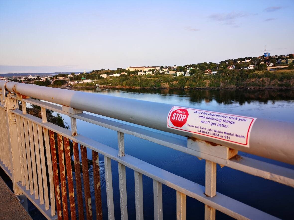 A suicide prevention sign on the railing at the Reversing Falls Bridge. (Submitted by Jaclyn McColgan - image credit)