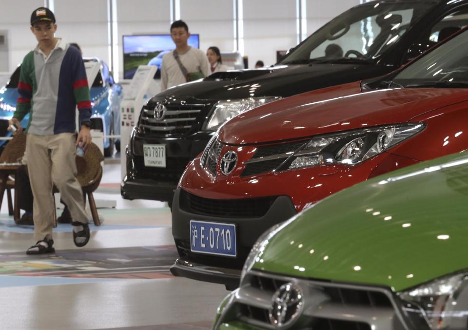 Visitors looks at cars displayed at a Toyota gallery in Tokyo Thursday, May 8, 2014. Toyota's fourth quarter profit dropped slightly despite higher vehicle sales and a weak yen as it spend more on research and development. Toyota Motor Corp. reported Thursday a January-March profit of 297 billion yen ($2.9 billion), down from 313.9 billion yen a year earlier. Quarterly sales rose 12.5 percent to 6.57 trillion yen ($64.5 billion). (AP Photo/Koji Sasahara)