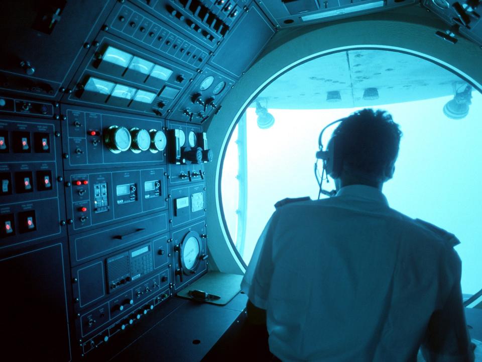 An individual navigates a submarine.