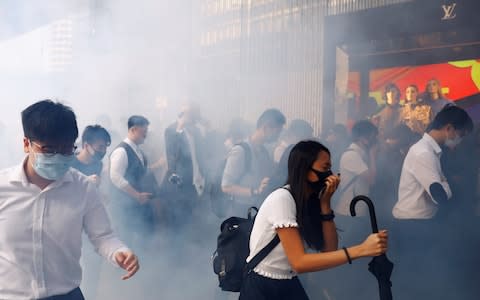 Office workers react after police fired tear gas, in Central, Hong Kong - Credit: &nbsp;REUTERS/Thomas Peter