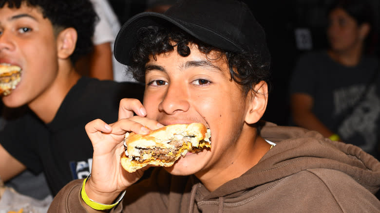 teen boy with mrbeast burger in mouth