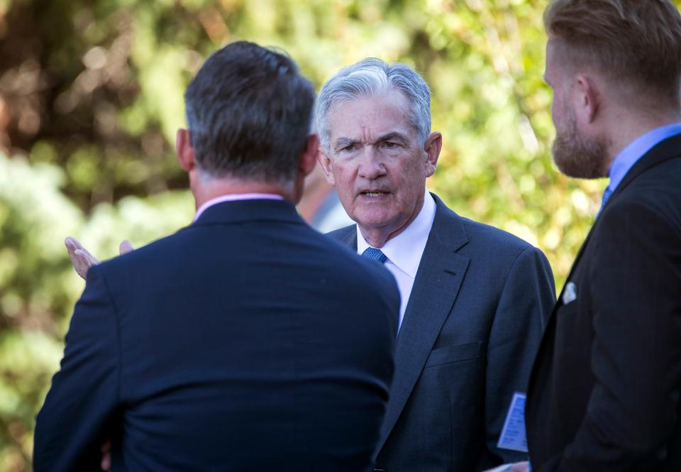 Federal Reserve Chair Jerome Powell, center, takes a coffee break with attendees of the central bank's annual symposium at Jackson Lake Lodge in Grand Teton National Park Friday, Aug. 26, 2022. in Moran, Wyo.