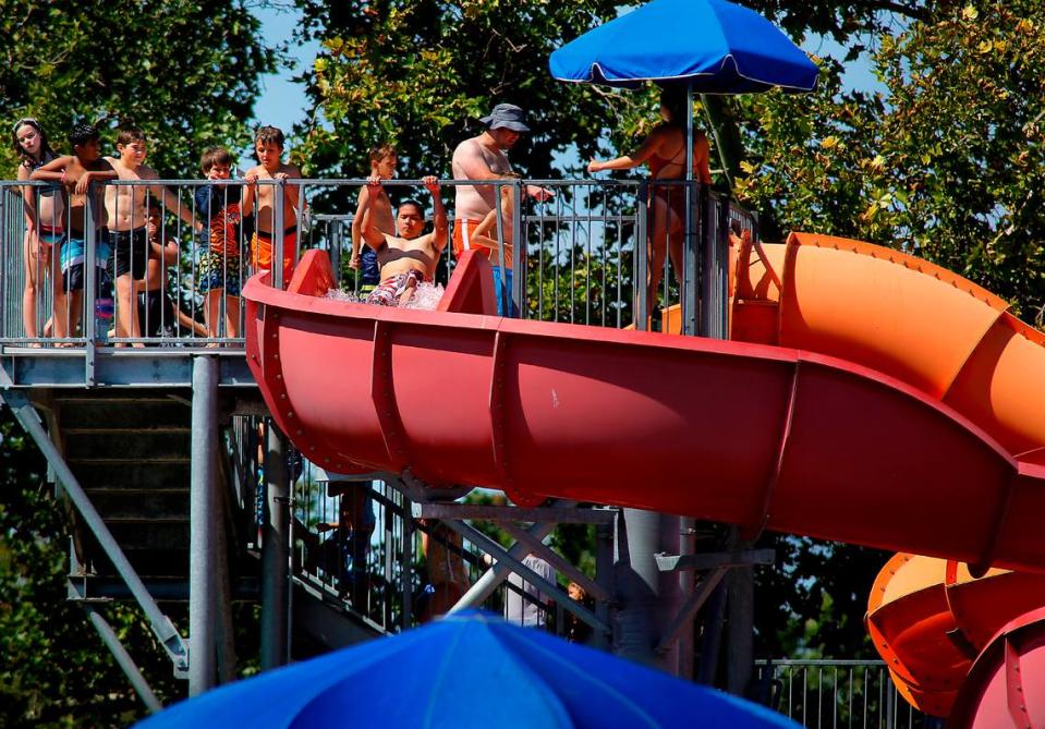 Swimmers line up for a trip down the water slides at Pasco’s Memorial Park Pool. The National Weather Service has issued an excessive heat advisory.