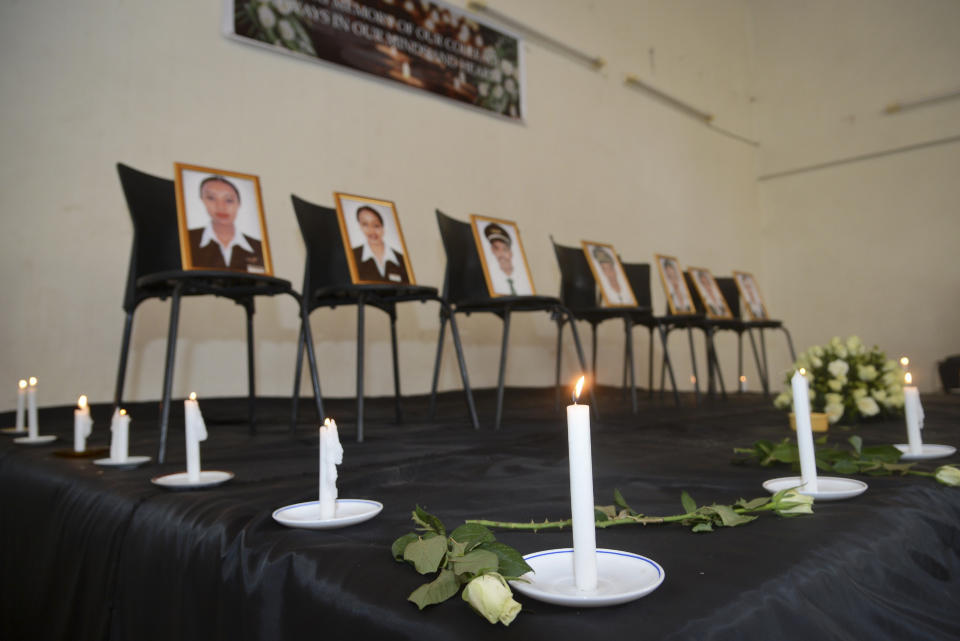 Framed photographs of seven crew members are displayed at a memorial service. Source: AP