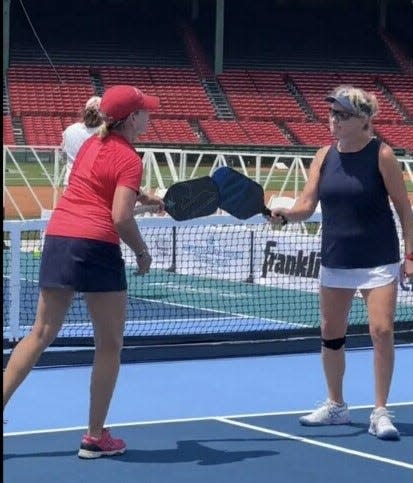 Sudbury's Christine McNamara, left, taps paddles with Lynn Kerr during the Pickle4 Ballpark Series tournament on July 12 at Fenway Park.