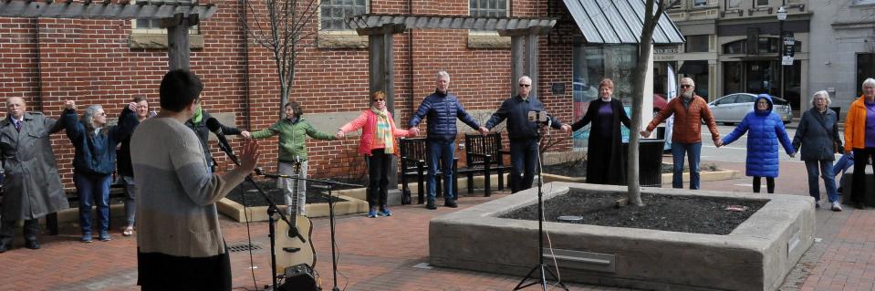 Roughly 36 people held hands as they closed the Good Friday ceremony in downtown Wooster singing "They'll Know We Are Christians by Our Love."