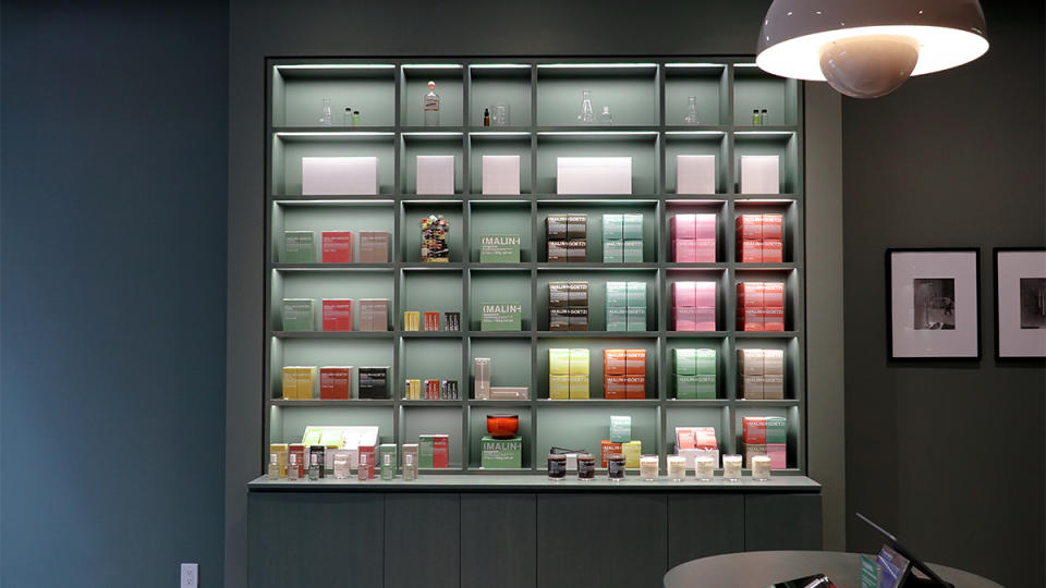 A colorful display of Malin+Goetz candles and perfumes at the location.