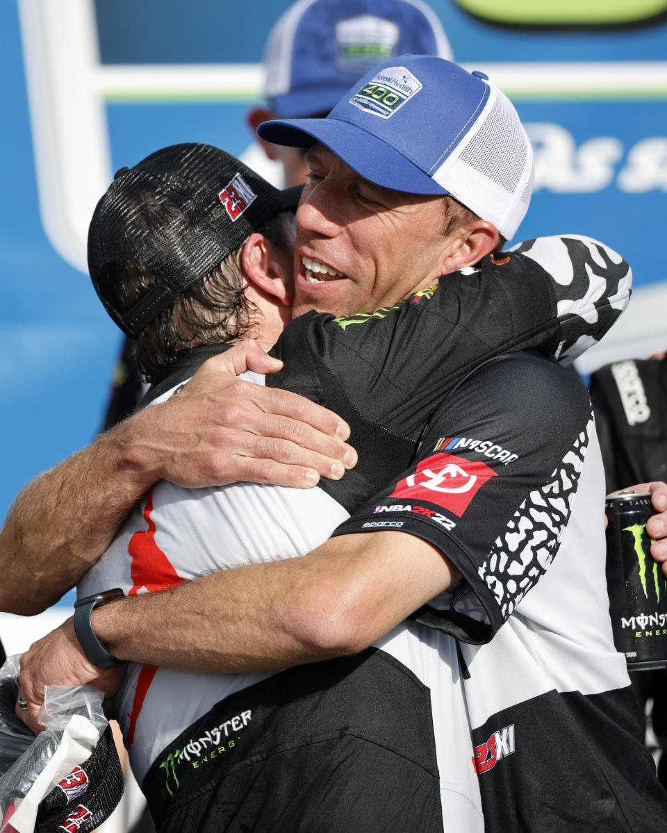 Billy Scott, crew chief for 23XI Racing, right, hugs driver, Kurt Busch, left, in Victory Lane follow Busch's win of a NASCAR Cup Series auto race at Kansas Speedway in Kansas City, Kan., Sunday, May 15, 2022. (AP Photo/Colin E. Braley)