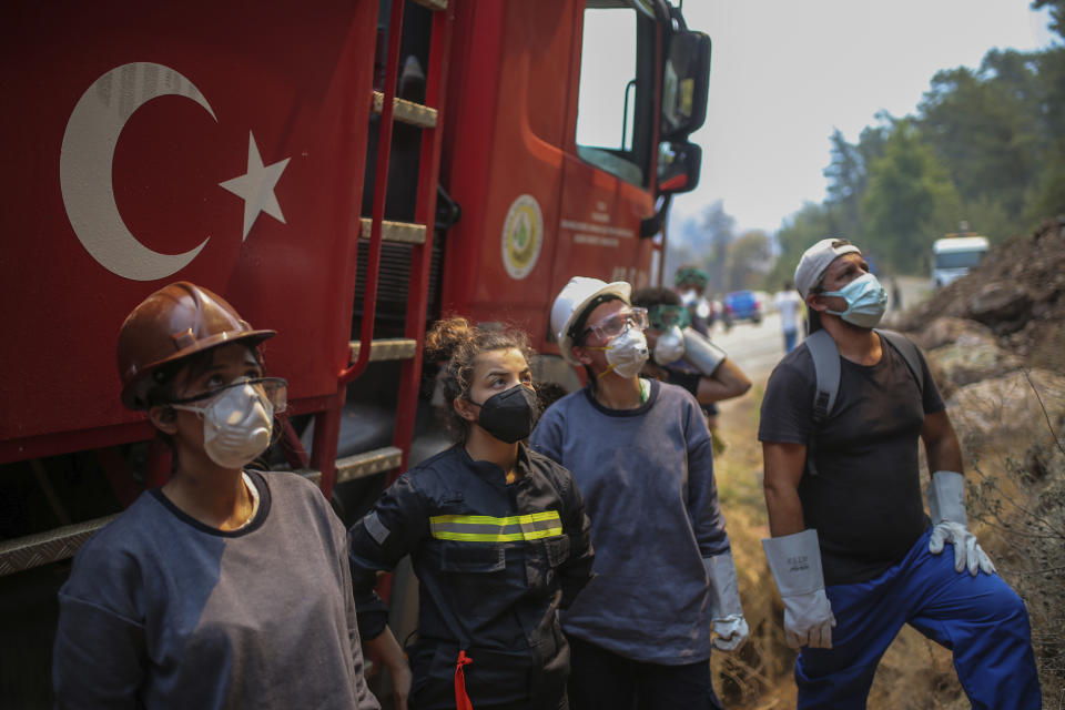 Turkish volunteers prepare to fight wildfires in Turgut village, near tourist resort of Marmaris, Mugla, Turkey, Wednesday, Aug. 4, 2021. Hundreds of volunteers have joined efforts to contain blazes that have swept through forests in Turkey's southern and southwestern coasts, fueled by a summer heatwave, low humidity and strong winds. The fires, described as Turkey's worst in living memory, have so far killed eight people _ including a teenaged volunteer who was carrying drinking water and other refreshments to firefighters in Marmaris. (AP Photo/Emre Tazegul)