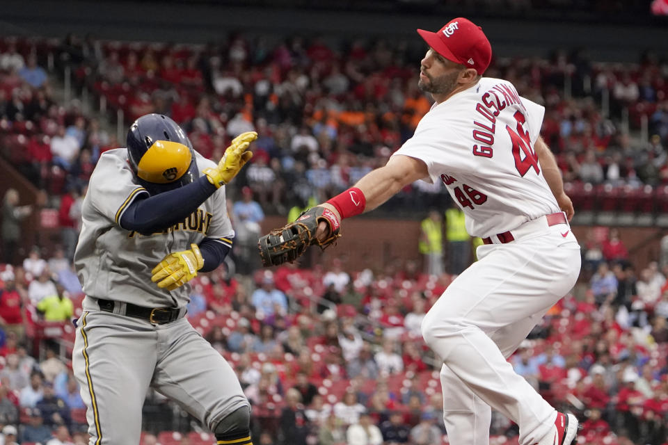 Milwaukee Brewers' Luis Urias, left, is safe at first as he avoids the tag from St. Louis Cardinals first baseman Paul Goldschmidt during the second inning of a baseball game Thursday, May 26, 2022, in St. Louis. Cardinals shortstop Edmundo Sosa was charged with a throwing error on the play. (AP Photo/Jeff Roberson)