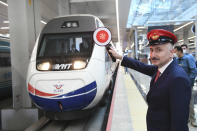 In this photo provided by Turkey's Transportation Ministry, Minister Adil Karaismailoglu poses for images as a train departs for Istanbul from Ankara's train station, Turkey, Thursday, May 28, 2020. Turkey has resumed limited intercity train operations after a two-month suspension as the country eases restrictions imposed to contain the coronavirus outbreak.(Transportation Ministry via AP )