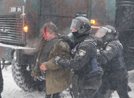 Riot police detain an anti-government protester, as service members of the National Guard remove a protest tent camp, near the parliament building in Kiev, Ukraine March 3, 2018. REUTERS/Gleb Garanich