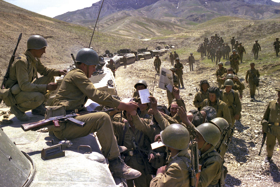 FILE - In this undated photo, Soviet soldiers receive newspapers and mail as a convoy stops somewhere in Afghanistan. When the Soviet Union completed its troops withdrawal from Afghanistan on Feb. 15, 1989, it was widely hailed as a much-anticipated end to a bloody quagmire, but public perceptions have changed and many Russians now see the 10-year Soviet war in Afghanistan as a necessary and largely successful endeavor. (Leonid Yakutin, Defense Ministry Press Service via AP, File)