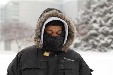 A man waits for a transit bus in several inches of snow in Detroit, Michigan January 2, 2014. REUTERS/Joshua Lott