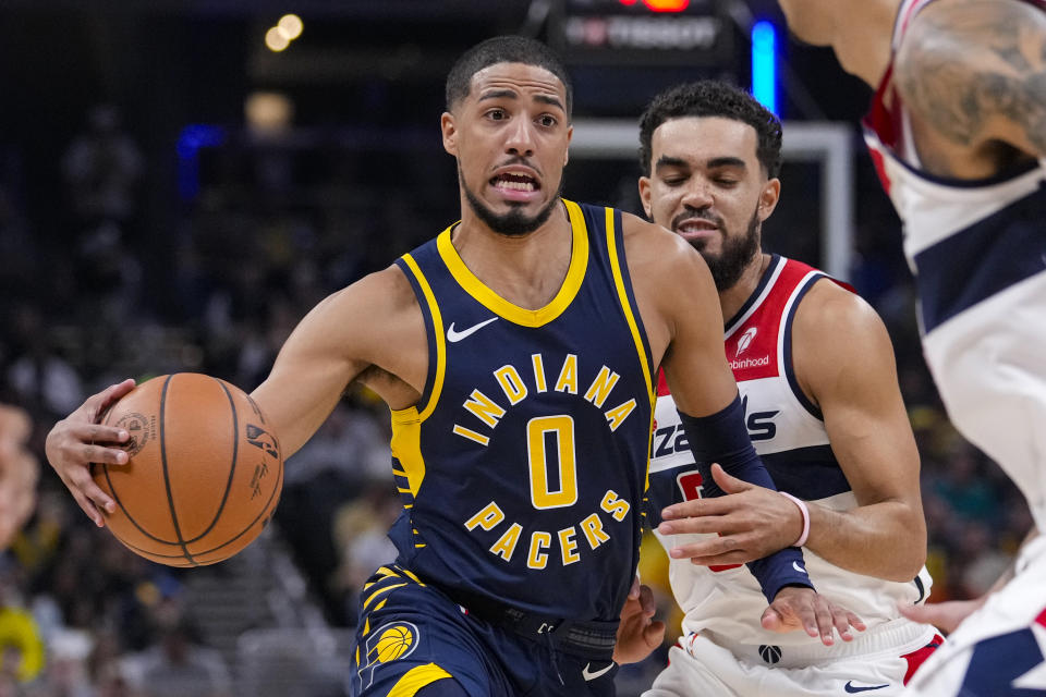 Indiana Pacers guard Tyrese Haliburton (0) drives on Washington Wizards guard Tyus Jones (5) during the first half of an NBA basketball game in Indianapolis, Wednesday, Oct. 25, 2023. (AP Photo/Michael Conroy)