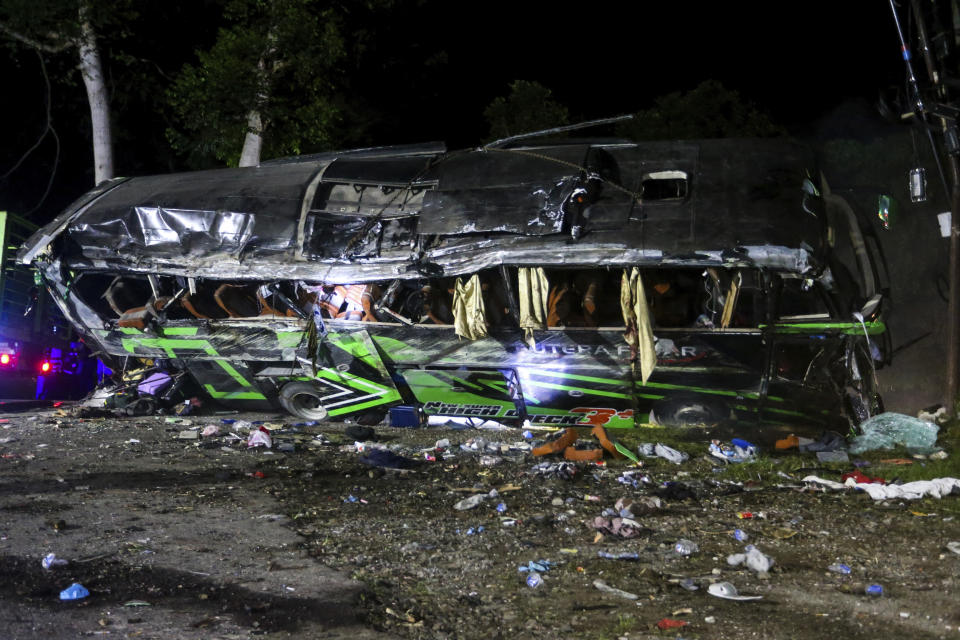 The wreckage of a bus lies on the side of a road following an accident in Subang, West Java, Indonesia, late Saturday, May 11, 2024. The bus carrying high school students and teachers returning from an outing smashed into cars and motorbikes in Indonesia's West Java province, killing a number of people on board. (AP Photo/Ryan Suherlan)