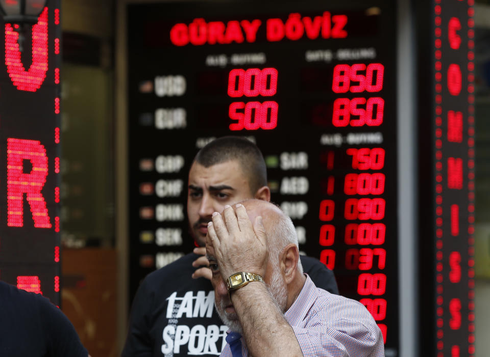 FILE-In this Thursday, Aug. 16, 2018 file photo, a man walks away after changing currency at a currency exchange shop in Istanbul. Turkey's currency dropped to an all-time low against the dollar on Thursday Aug. 6, 2020, as the global recession created by the coronavirus pandemic brings to the fore weaknesses in the country's economy. (AP Photo/Lefteris Pitarakis, File)