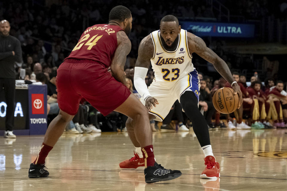 Los Angeles Lakers forward LeBron James (23) dribbles against Cleveland Cavaliers forward Marcus Morris Sr. (24)during the first half of an NBA basketball game Saturday, April 6, 2024, in Los Angeles. (AP Photo/William Liang)