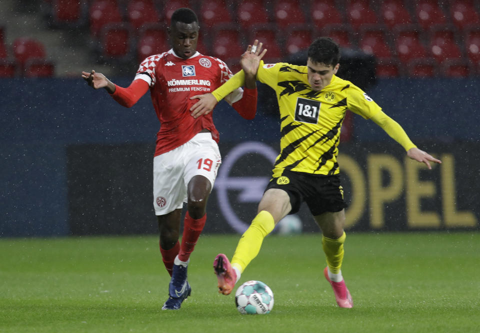 Mainz's Moussa Niakhate, left, vies for the ball with Dortmund's Giovanni Reyna during the German Bundesliga soccer match between FSV Mainz 05 and Borussia Dortmund in Mainz, Germany, Sunday, May 16, 2021. (AP Photo/Michael Probst,Pool)