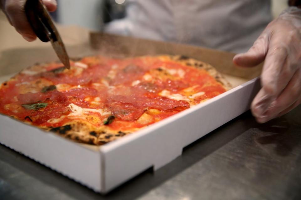 Michele Rubini slices a pizza for an order at L'Antica Pizzaria da Michele in Hollywood.