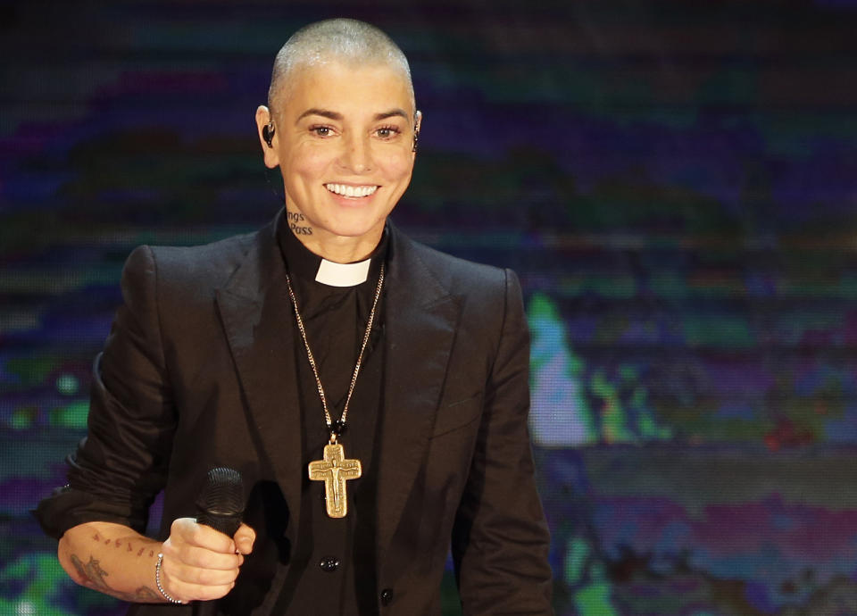FILE - Irish singer Sinead O'Connor performs during the Italian State RAI TV program "Che Tempo che Fa", in Milan, Italy on Oct. 5, 2014. O’Connor’s family has invited the public to line the waterfront in Bray on Tuesday, Aug. 8, 2023 as her funeral procession passes by. Fans left handwritten notes outside her former home, thanking her for sharing her voice and her music. (AP Photo/Antonio Calanni, File)