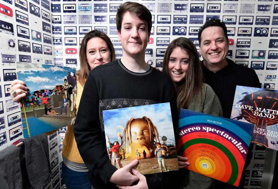 From left, Shay Toland and her two teenagers, 15-year-old Maeve and 17-year-old Aidan, and Husband Brian, with albums in front of tape cassette wallpaper at their home, examples of how so many old-school items - records, Dungeons  and  Dragons, etc - are back in vogue. 