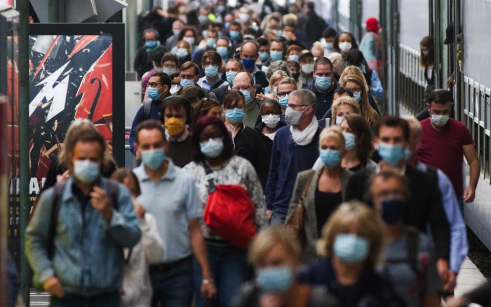 Morning rush hour commuters wear protective face masks