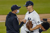 New York Yankees starting pitcher Jameson Taillon smiles after giving the ball to manager Aaron Boone, left, during the fifth inning of the team's baseball game against the Baltimore Orioles, Wednesday, April 7, 2021, at Yankee Stadium in New York. Taillon made his first start in the majors since May 1, 2019. (AP Photo/Kathy Willens)