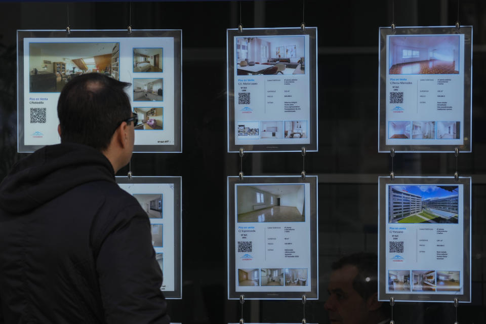 A man looks in the window of an estate agency with properties mainly for sale in Madrid, Spain, Tuesday, April 18, 2023. Spain's leftist coalition government has approved a plan to make available some 50,000 houses for rent at affordable prices as part of measures aimed at curbing soaring rents and house prices. The apartments will come from the state-controlled SAREB 'bad bank' that was set up in 2012 to relieve troubled banks of their most toxic assets during the international financial crisis. (AP Photo/Paul White)