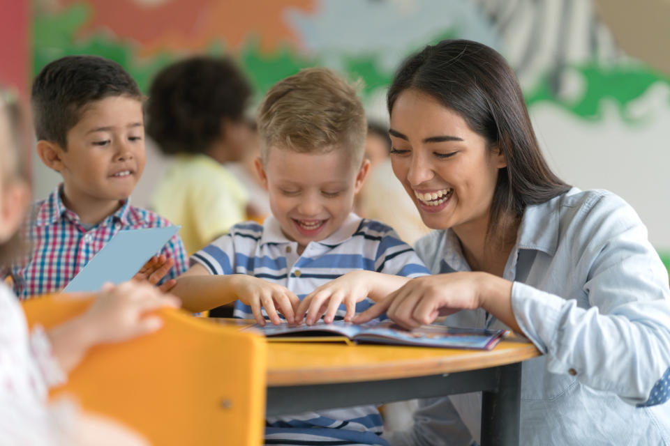 A teacher looking at a book with students