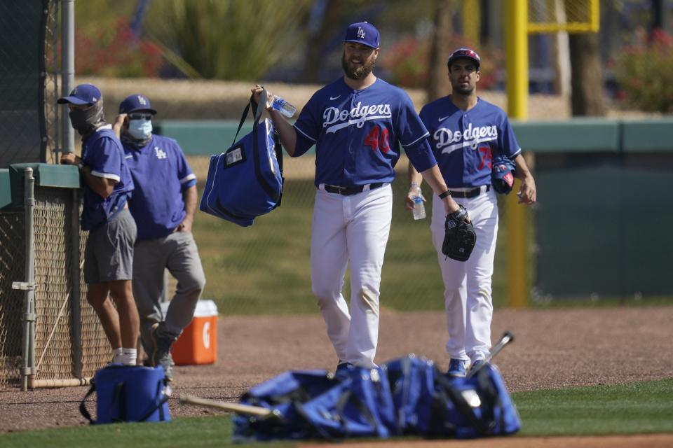 Los Angeles Dodgers pitchers Jimmy Nelson and Scott Alexander (75) make their way on to a new practice field during a spring training baseball practice Tuesday, Feb. 23, 2021, in Phoenix. (AP Photo/Ross D. Franklin)