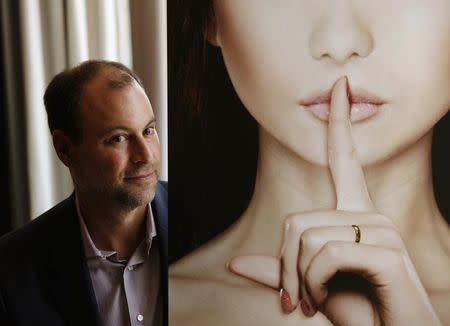 Ashley Madison founder Noel Biderman poses with a poster during an interview at a hotel in Hong Kong August 28, 2013. REUTERS/Bobby Yip