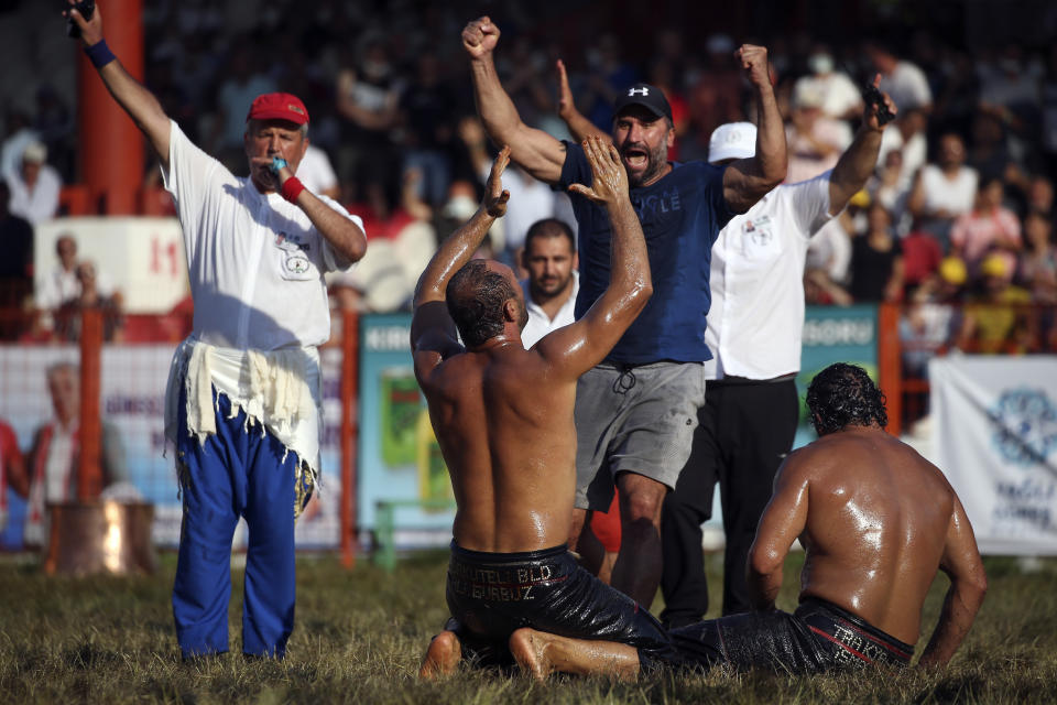 Wrestler Ali Gurbuz, center, celebrates after winning the final to gain the sport's golden belt in the 660th instalment of the annual Historic Kirkpinar Oil Wrestling championship, in Edirne, northwestern Turkey, Sunday, July 11, 2021. Thousands of Turkish wrestling fans flocked to the country's Greek border province to watch the championship of the sport that dates to the 14th century, after last year's contest was cancelled due to the coronavirus pandemic. The festival, one of the world's oldest wrestling events, was listed as an intangible cultural heritage event by UNESCO in 2010. (AP Photo/Emrah Gurel)