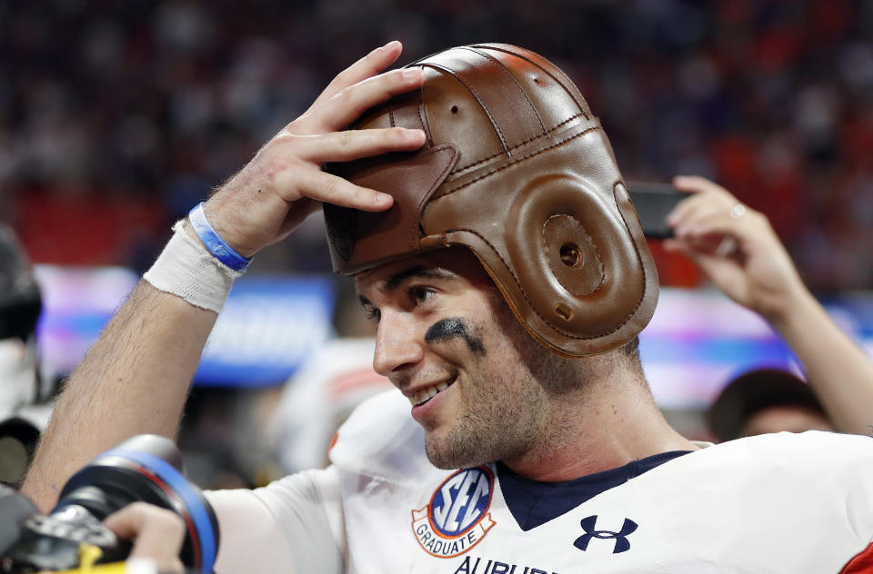 Auburn quarterback Jarrett Stidham tries on the "Old Leather Helmet" after Auburn defeated Washington 21-16 in an NCAA college football game Saturday, Sept. 1, 2018, in Atlanta. (AP Photo/John Bazemore)