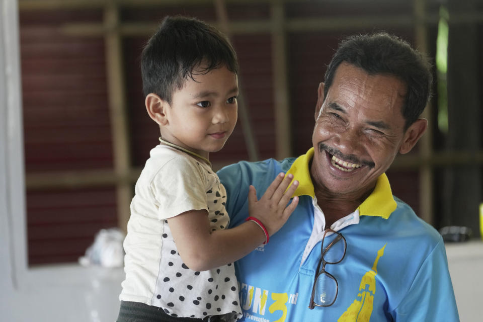 Tawee Lasopha holds his grandson Thanathorn Sopha, son of his daughter Maliwan Lasopha who was killed in a knife and gun attack at The Young Children's Development Center, in the rural town of Uthai Sawan, in Nong Bua Lamphu province, northeastern Thailand, Wednesday, Oct. 4, 2023. On Friday, Oct. 6, Tawee marks the first anniversary of the death of his daughter Maliwan Lasopha. (AP Photo/Sakchai Lalit)