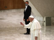 Pope Francis salutes faithful at the end of his weekly general audience in the Paul VI Hall at the Vatican, Wednesday, Oct. 28, 2020. Pope Francis has blamed “this lady COVID” for forcing him to keep his distance from the faithful during his general audience, which was far smaller than usual amid soaring coronavirus infections in Italy. (AP Photo/Alessandra Tarantino)