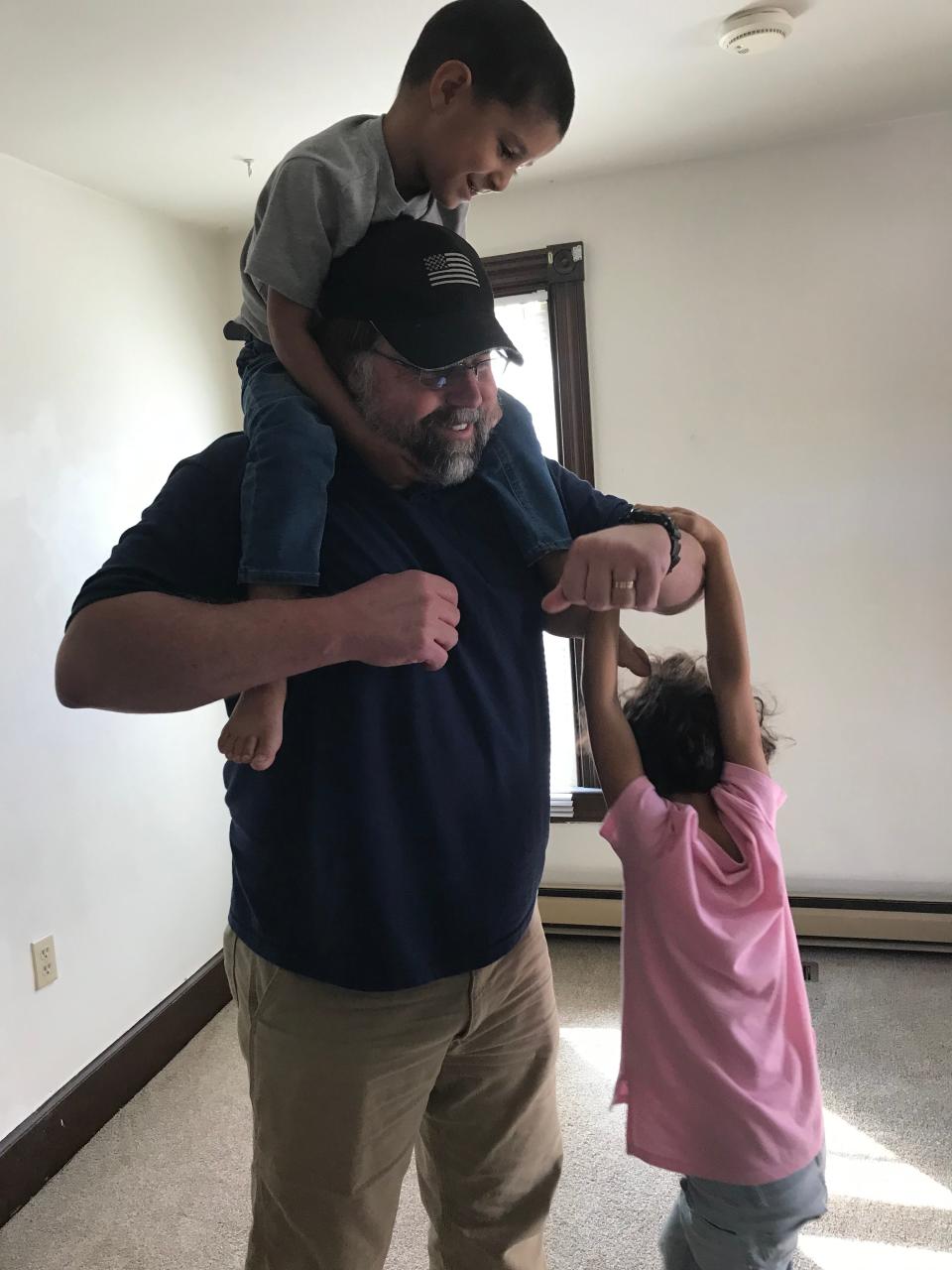 Matt Coburn, a retired Green Beret, plays with Zainab and Rashid as the family moves in to their new rental house in Pennsylvania.