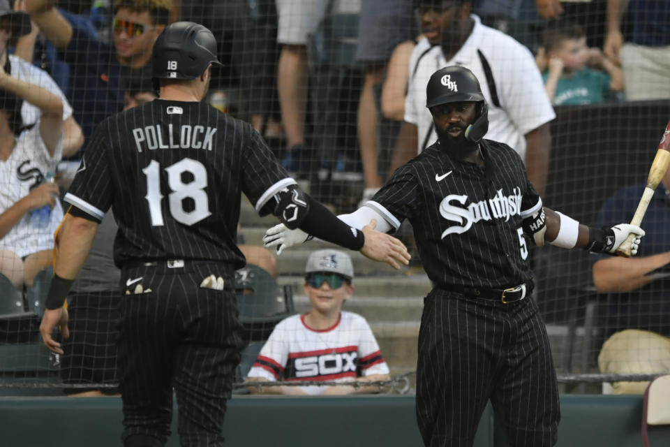 Chicago White Sox's A.J. Pollock (18) celebrates with teammate Josh Harrison (5) after scoring on a Adam Engel double during the second inning of a baseball game against the Toronto Blue Jays, Tuesday, June 21, 2022, in Chicago. (AP Photo/Paul Beaty)