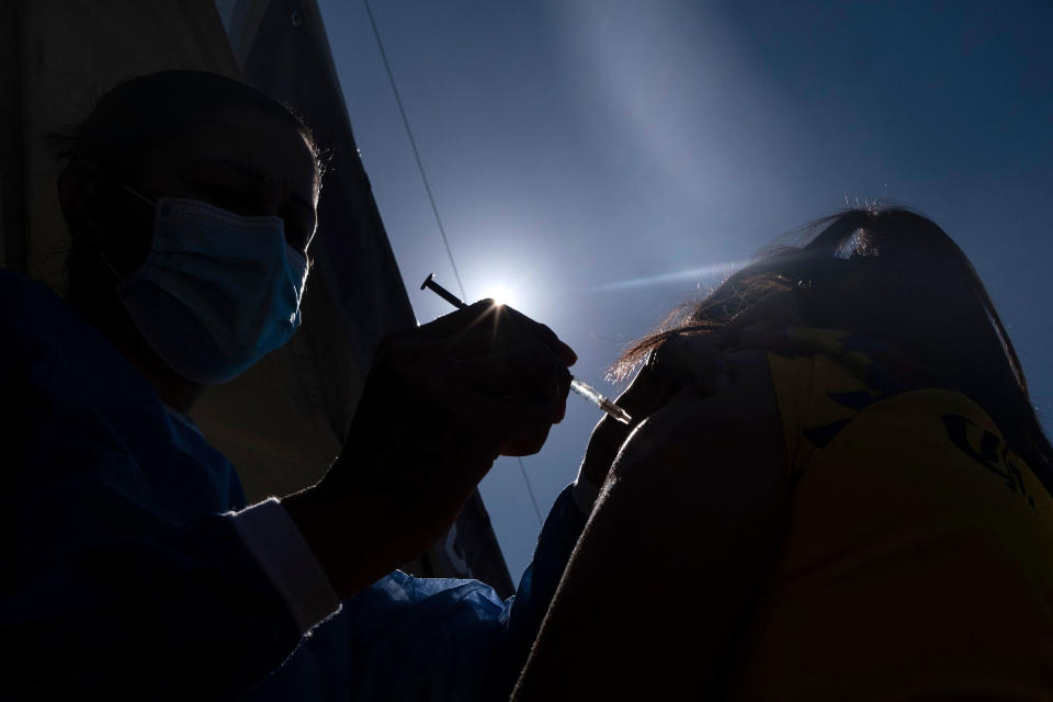 An asylum seeker camping on the border with the U.S. in Tijuana, Mexico, is vaccinated against COVID-19 on Aug. 3<span class="copyright">Guillermo Arias—AFP/Getty Images</span>
