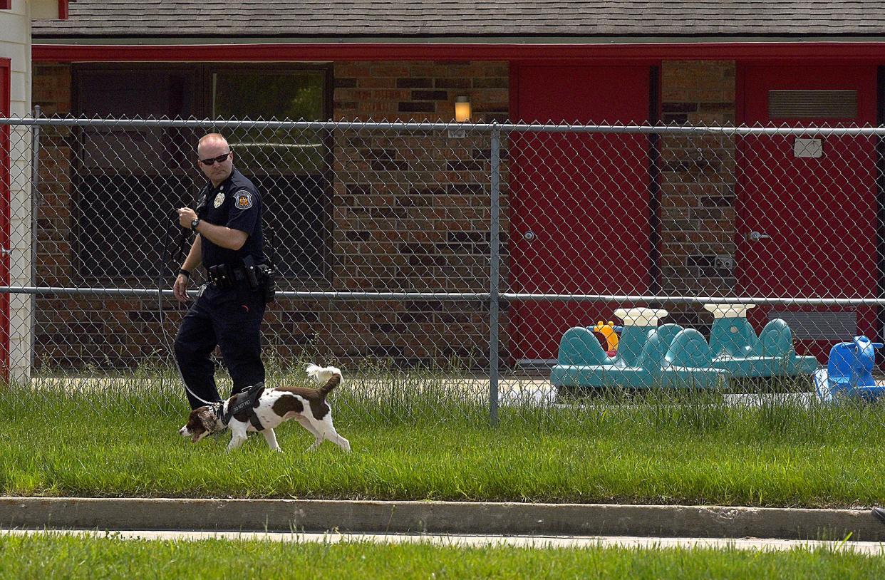 Missouri Capitol Police officer Adam Hoskins and his explosive device-detection K-9 “Burbon” search the lawn outside the KinderCare Learning Center at 2416 W. Ash St. at about 1:05 p.m. May 17. The day care was evacuated by police and firefighters after someone called in a bomb threat.