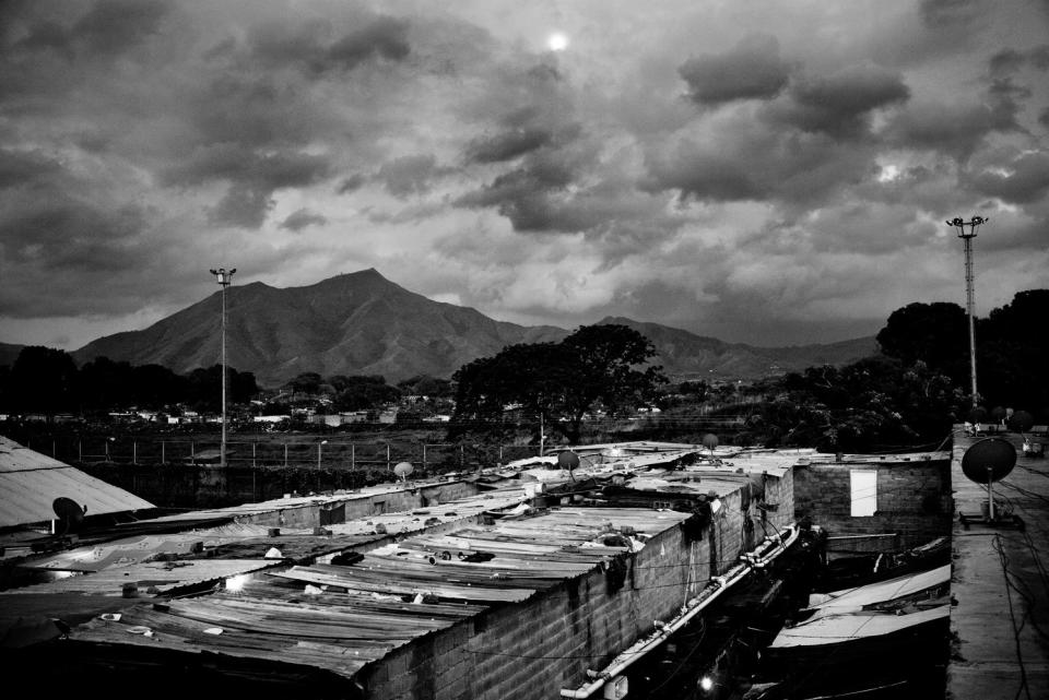 Shelters are seen lined up, with mountains in the background.