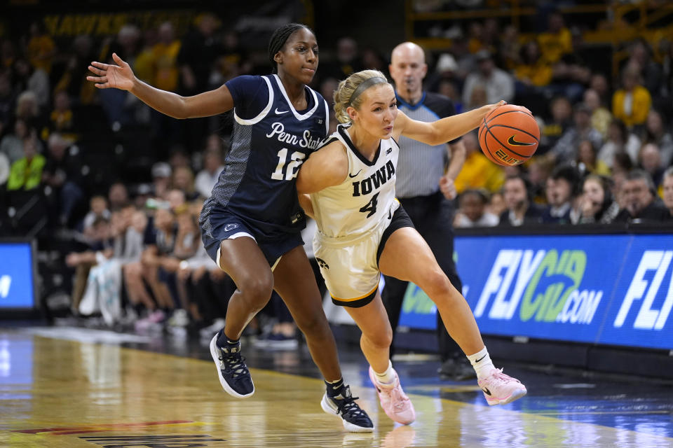 Iowa guard Kylie Feuerbach (4) drives past Penn State guard Jayla Oden (12) during the second half of an NCAA college basketball game, Thursday, Feb. 8, 2024, in Iowa City, Iowa. Iowa won 111-93. (AP Photo/Charlie Neibergall)