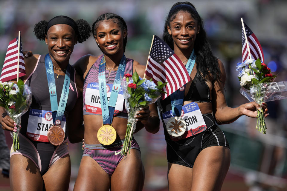 First place winner Masai Russell, center, Alaysha Johnson, at second place, right stand with third place winner Grace Stark after the win the women's 100-meter hurdles final during the U.S. Track and Field Olympic Team Trials, Sunday, June 30, 2024, in Eugene, Ore. (AP Photo/George Walker IV)