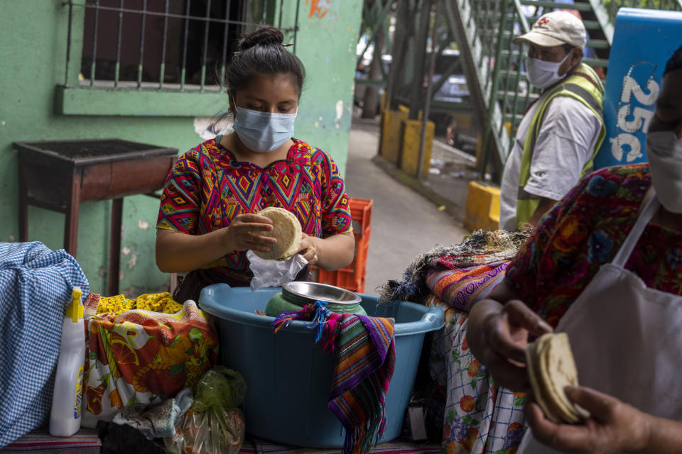 An indigenous woman counts corn tortillas at La Palmita market in Guatemala City, Saturday, Oct. 16, 2021. While greater numbers of Guatemalan women are getting a formal education, discrimination, poverty and the need to support a family keep many – especially the Indigenous – out of school. (AP Photo/Moises Castillo)