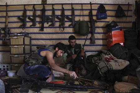 Free Syrian Army fighters sit inside a weapons warehouse in Kansafra, in Idlib province September 3, 2013. REUTERS/Loubna Mrie