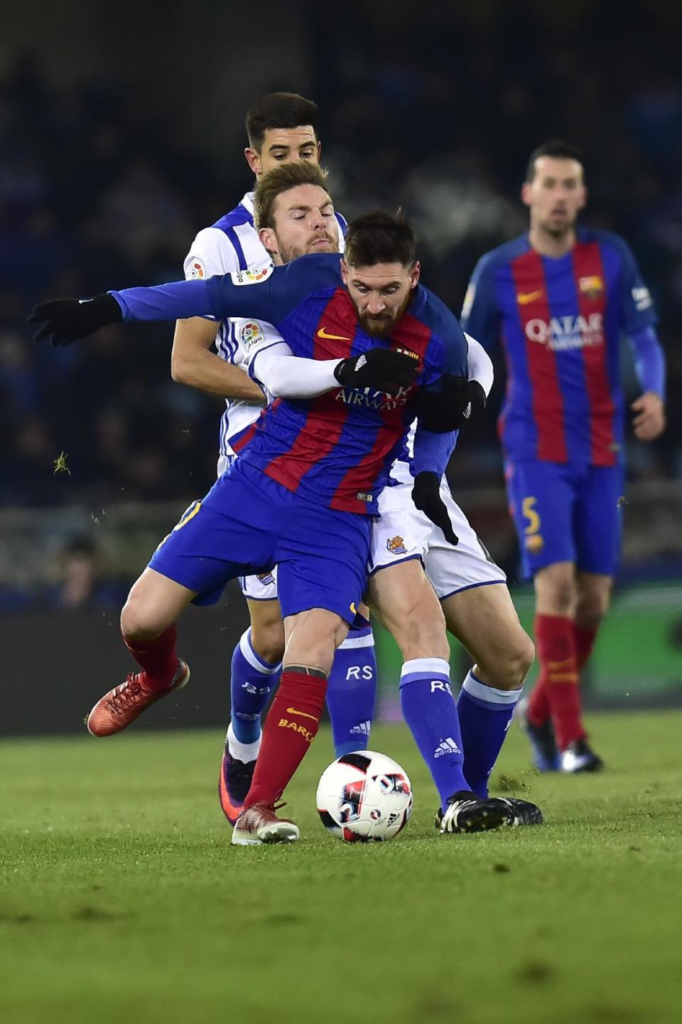 FC Barcelona's Lionel Messi, duels for the ball with Real Sociedad's Aritz Elustondo during the Spanish Copa del Rey, quarter final, first leg soccer match, between FC Barcelona and Real Sociedad, at Anoeta stadium, in San Sebastian, northern Spain, Thursday, Jan.19, 2017. (AP Photo/Alvaro Barrientos)