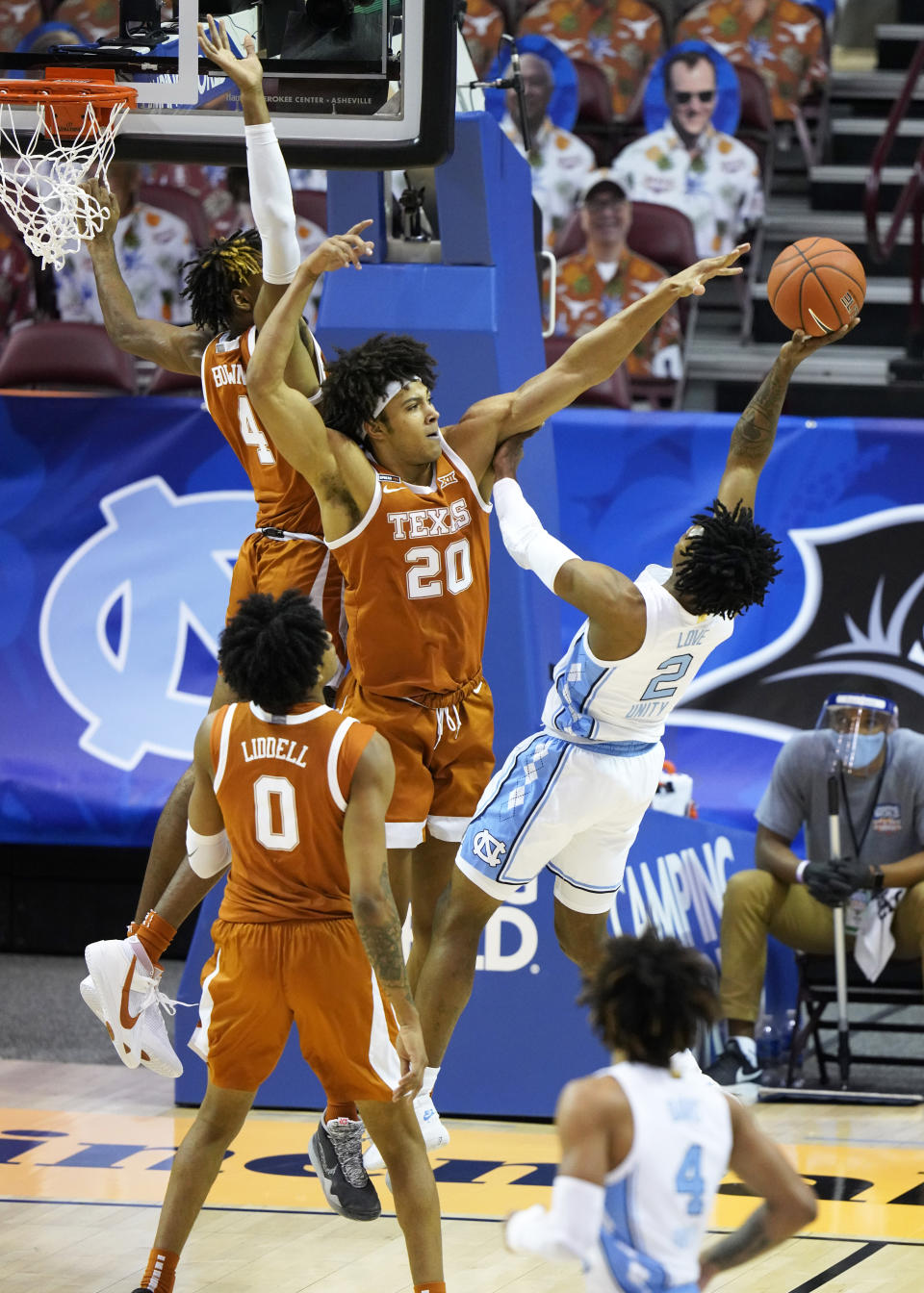 Texas forward Jericho Sims (20) blocks the shot North Carolina guard Caleb Love (2) as Texas forward Gerald Liddell (0) looks for the rebound 104in the first half an NCAA college basketball game for the championship of the Maui Invitational, Wednesday, Dec. 2, 2020, in Asheville, N.C. (AP Photo/Kathy Kmonicek)