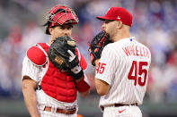 Philadelphia Phillies' J.T. Realmuto, left, and Zack Wheeler talk during the first inning of a baseball game against the San Diego Padres, Wednesday, May 18, 2022, in Philadelphia. (AP Photo/Matt Slocum)