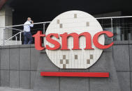 FILE - A person walks into the Taiwan Semiconductor Manufacturing Co., Ltd. (TSMC) headquarters in Hsinchu, Taiwan on Oct. 20, 2021. Beijing's threats to use force to claim self-governed Taiwan aren't just about missiles and warships. Hard economic realities will be at play as voters head to the polls on Saturday, though the relationship is complicated. (AP Photo/Chiang Ying-ying, File)