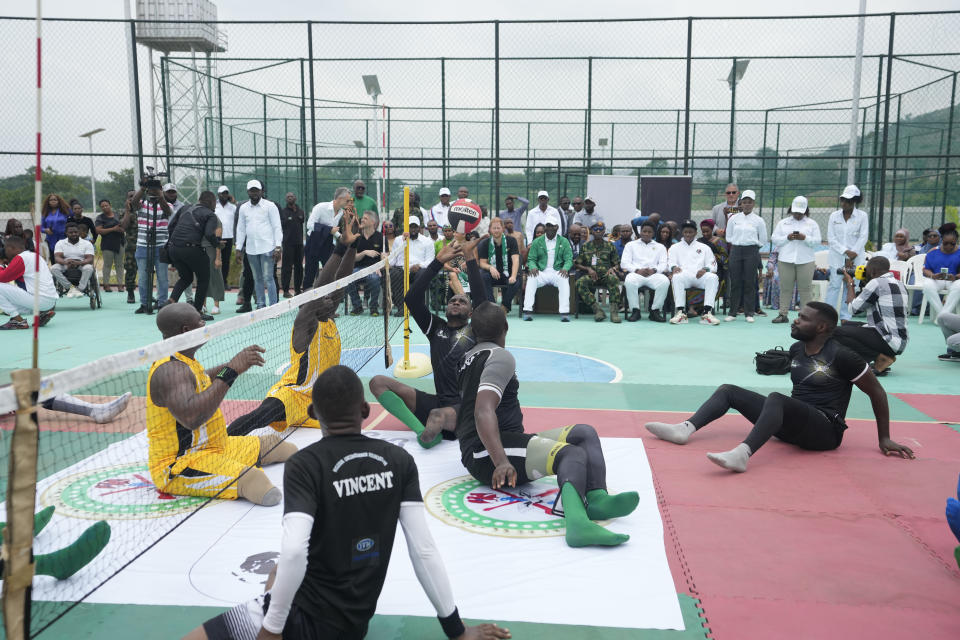 Sgt. Monday Peter whose two legs were amputated after an armored personnel carrier shattered his legs as they patroled villages in the northwestern Kaduna state in 2011, left, participates in an exhibition sitting volleyball match in Abuja Nigeria, Saturday, May 11, 2024. (AP Photo/Sunday Alamba)